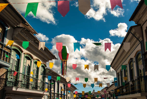 june party in brazil ("festas juninas" or "são joão" in portuguese). amazing multicolored flags and balloons decorate streets of small village. in background, blue sky, mountains and trees. travel photography. - são imagens e fotografias de stock