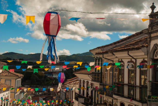 in firts plain coloured balloon and flags decorate street for june party in brazil. also named "festas juninas" or "são joão" in portuguese, these party are traditional in brazilian cultural heritage. - são imagens e fotografias de stock