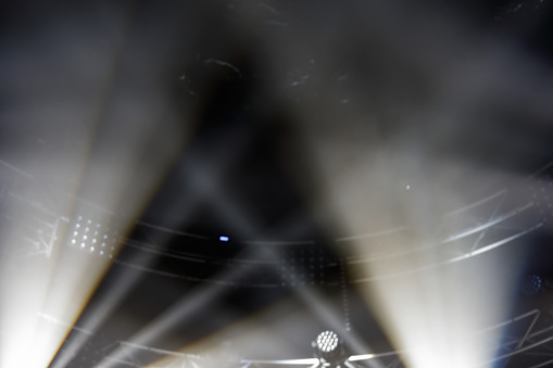 White beams of stage light during a show.