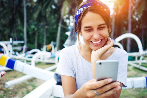 istock woman using cell phone near the beach 932050348