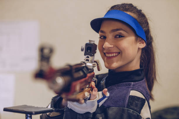 istock Young beautiful woman shoots at the shooting range 932051558