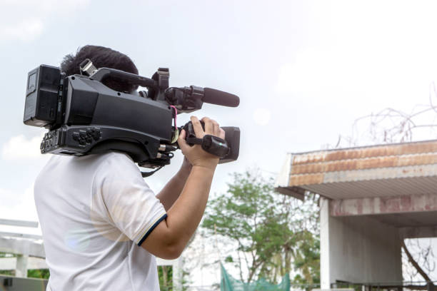 istock Covering an event with a video camera., Videographer takes video camera with free copy space for your text. 932052400