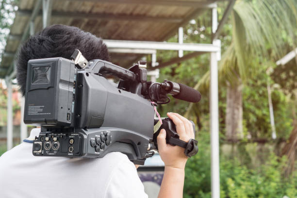 istock Covering an event with a video camera., Videographer takes video camera with free copy space for your text. 932052412