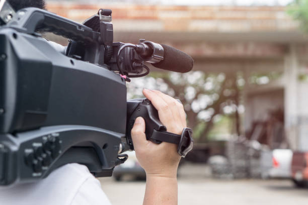 istock Covering an event with a video camera., Videographer takes video camera with free copy space for your text. 932052428