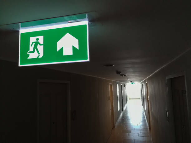 istock Fire escape the building, condo.A rather dark corridor and fire exit sign lights to make it visible. with copy space for text 932054962