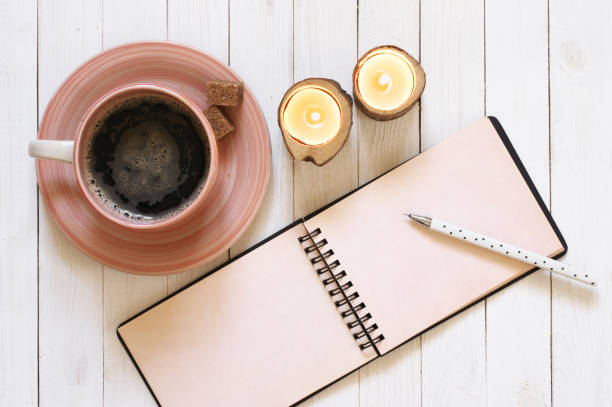 istock Notepad with pen, coffee and candles on desk 932056118