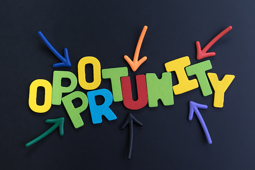 Colorful arrows pointing to the word OPPORTUNITY at the center on black chalkboard, concept of future opportunity in career path, job or work journey, motivation for life target or success in work.