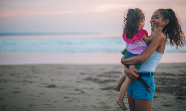 istock Mother and little daughter at the beach 932059208