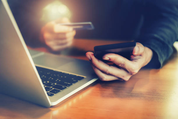 istock Online payment,Young Man's hands holding smartphone and using credit card and computer laptop for online shopping. 932069692