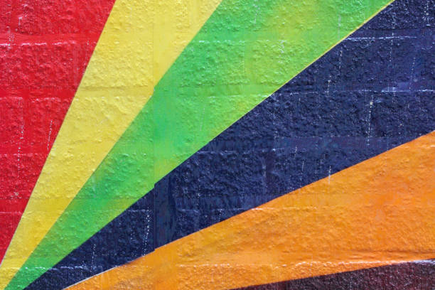 Rainbow painted brick wall A close up macro shot of diagonal colored lines radiating on an old brick wall in Columbus, OH mural stock pictures, royalty-free photos & images