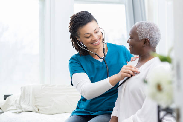 female nurse checks patient's vital signs - visit hospital patient senior adult imagens e fotografias de stock