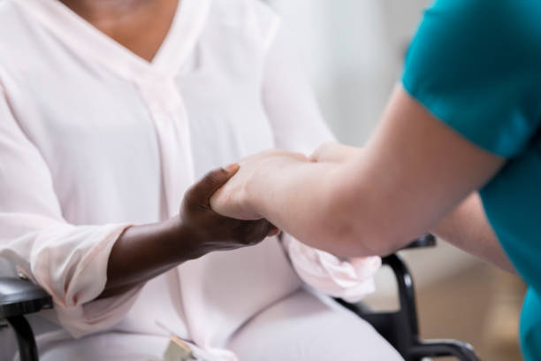 istock Nurse holds senior patient's hands 932074842