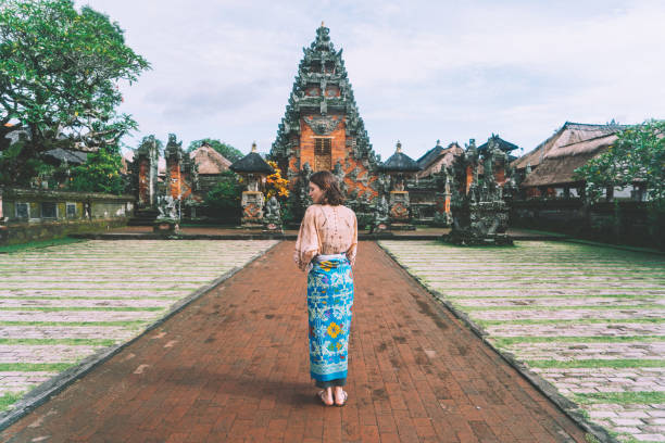 mujer caminando en templo balinés - bali indonesia temple travel fotografías e imágenes de stock