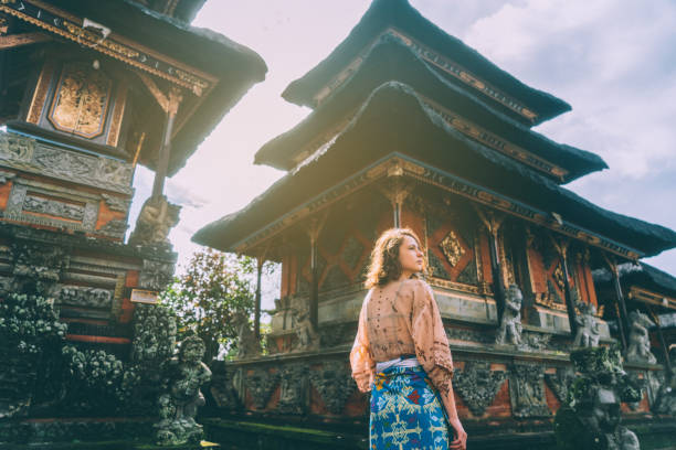 femme qui marche dans temple balinais - bali photos et images de collection