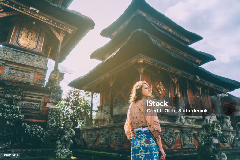 Woman walking in Balinese temple Young Caucasian woman walking in Balinese temple, Indonesia Travel Stock Photo