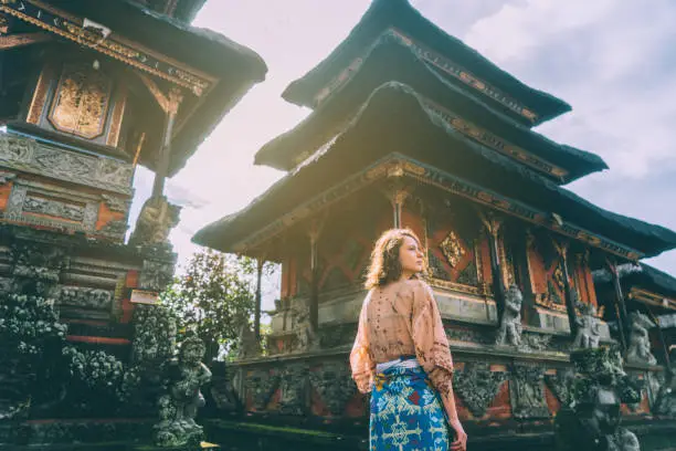 Young Caucasian woman walking in Balinese temple, Indonesia