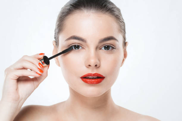 istock Mascara makeup woman face with red lips and manicure nails isolated on white. 932094324