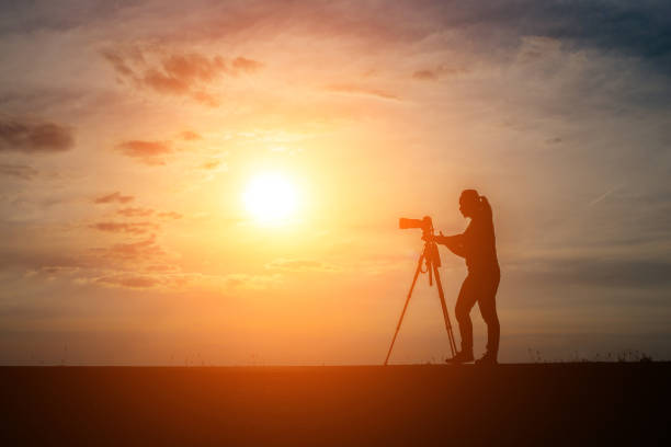 istock Silhouette of a photographer shoots a sunset. 932109148