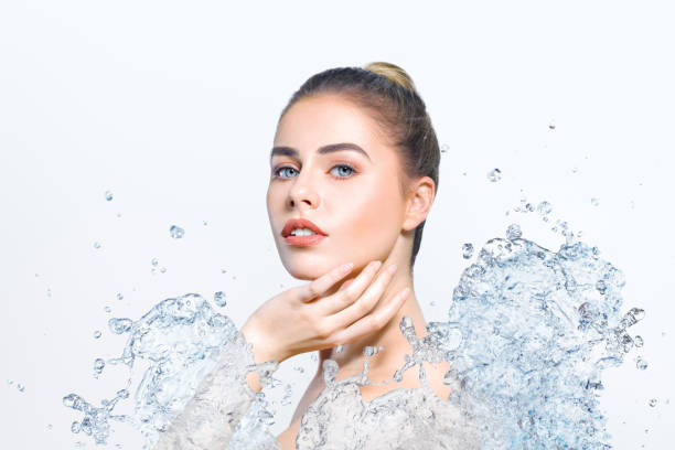 istock Young beautiful woman with water splash 932109182