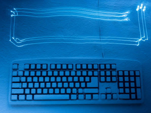 istock computer keyboard covered with snow illuminated by blue light with traces from drawing by light 932111348