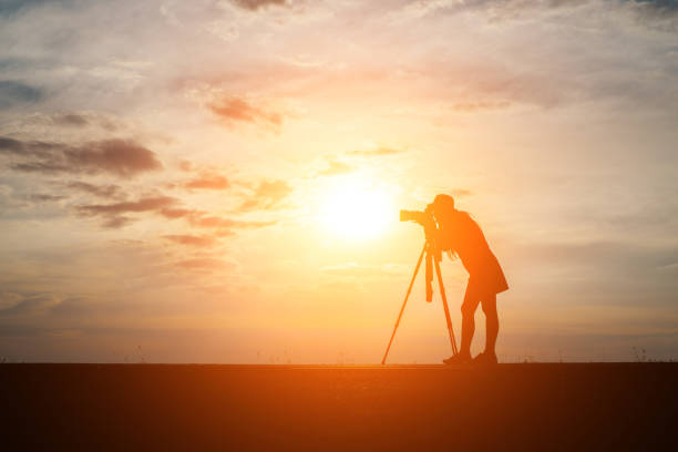 istock Silhouette of a photographer shoots a sunset. 932111592