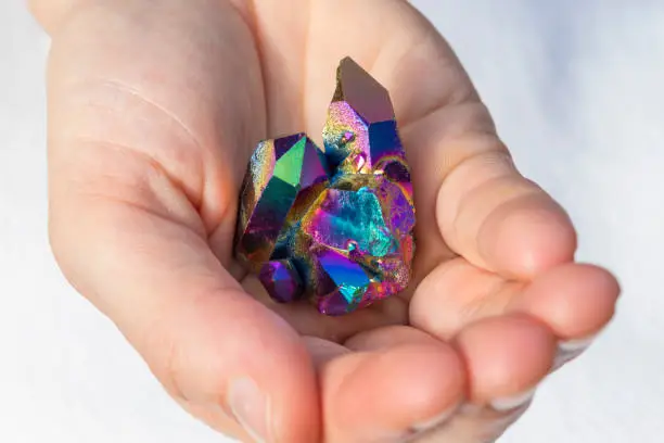 A beautiful piece of Rainbow Titanium Aura Crystal in hands.