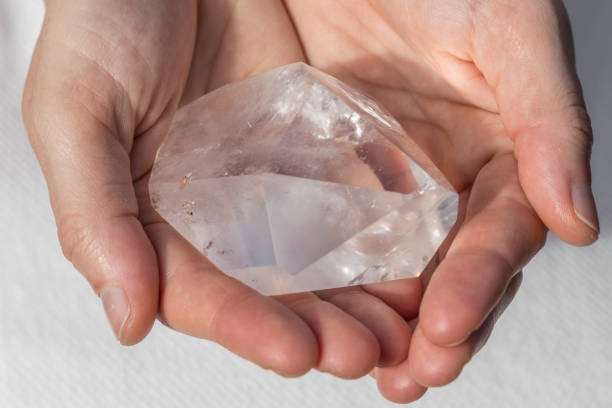 istock A beautiful large piece of quartz crystal in hands 932111678