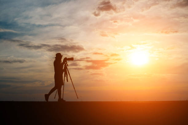 istock Silhouette of a photographer shoots a sunset. 932111820
