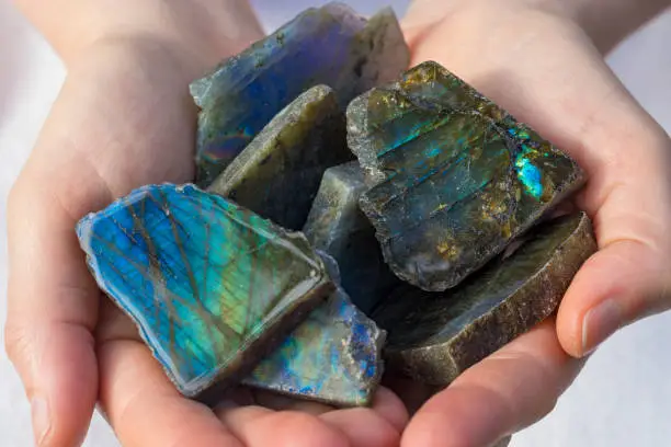 Several beautiful pieces of Labradorite crystal in hands.