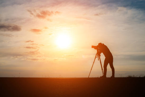 istock Silhouette of a photographer shoots a sunset. 932112012