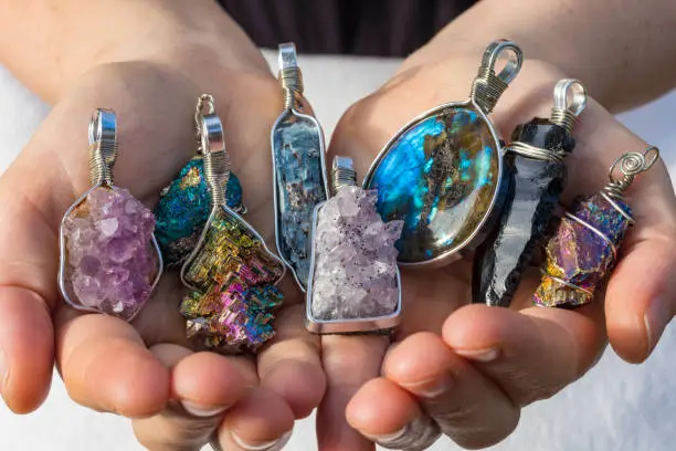 Several Beautiful Crystal Pendants in Hands.