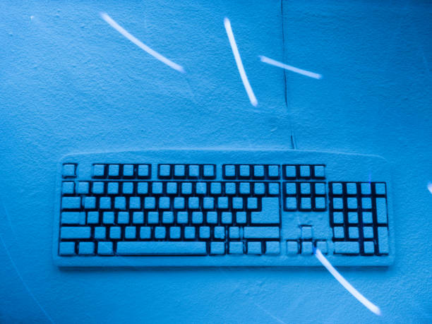 istock wired computer keyboard covered with blue illuminated snow with chaotic traces from light painting 932118006