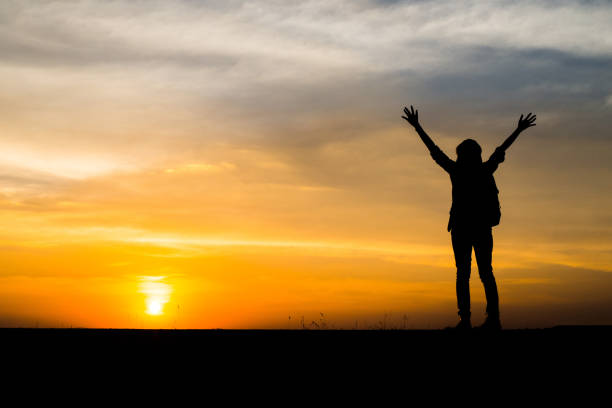 Hiker with backpack relaxing and enjoying sunset.