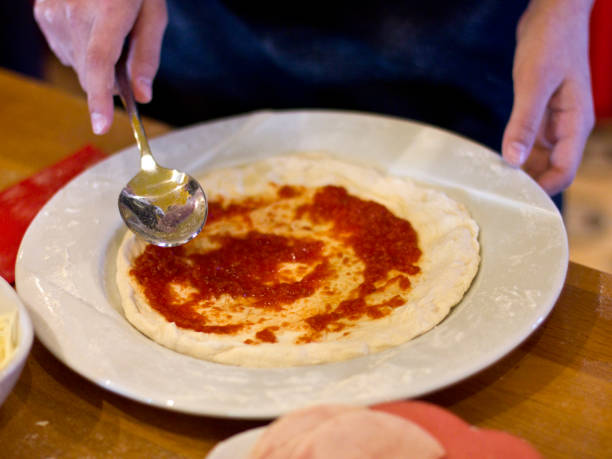 istock The cook is making pizza. Tomato sauce for a dough 932124934