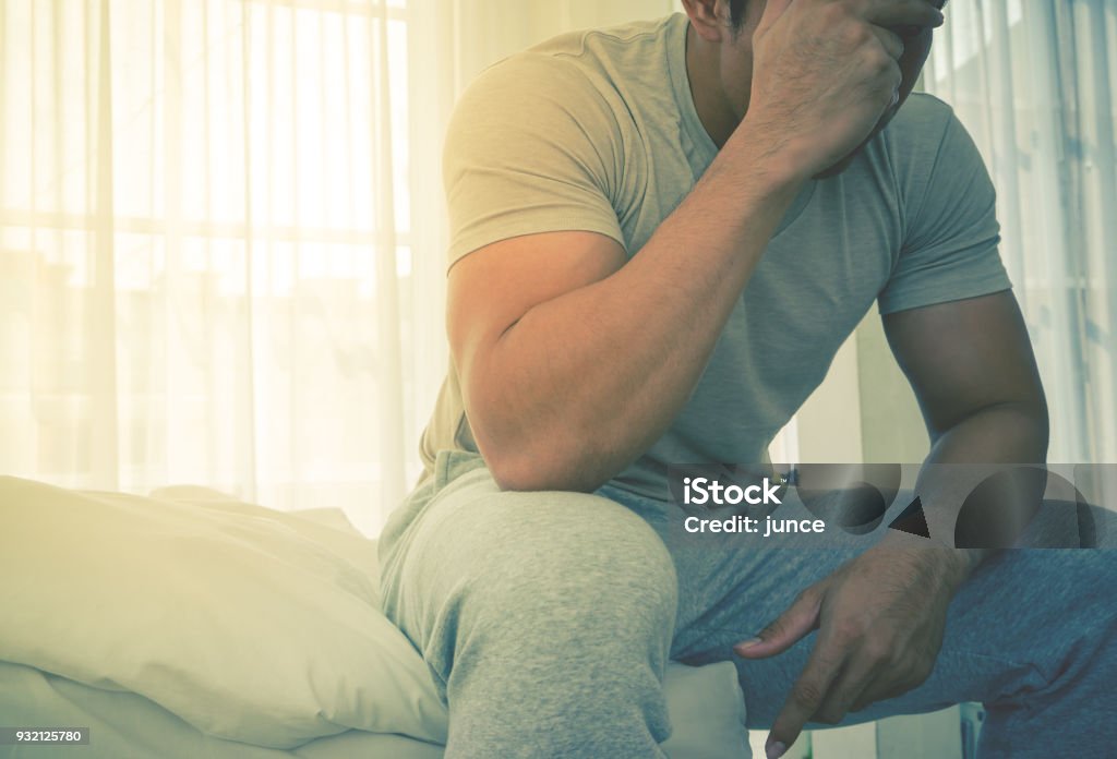 Homme en pyjama dépasse les maux de tête sur lit de se bloquer et stress matin - Photo de Hommes libre de droits