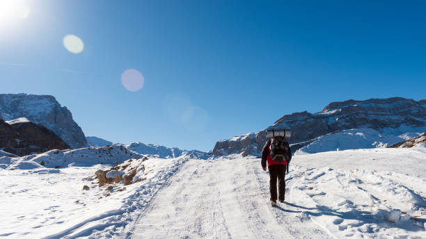 istock Traveler on snowy road in mountains 932128352