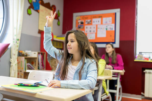 istock Schoolgirl raising hand at class 932130010