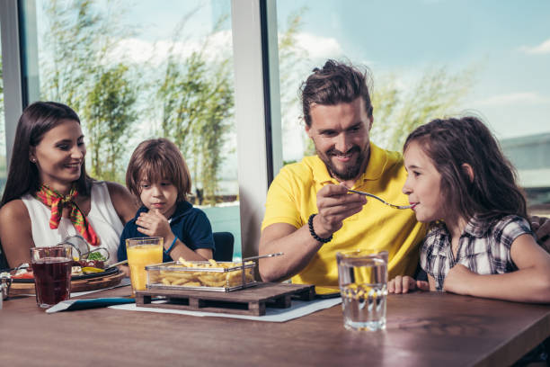 istock Family having enjoyable lunch at a restaurant. 932132810