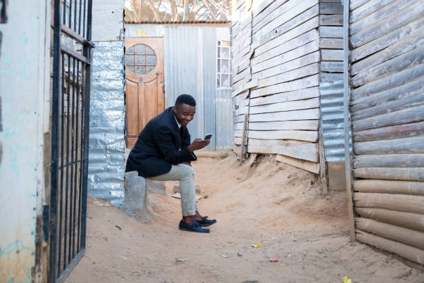 istock Black man sitting and using his mobile phone 932133272