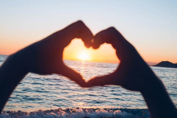 istock Sea at sunset with a silhouette of hands 932136594
