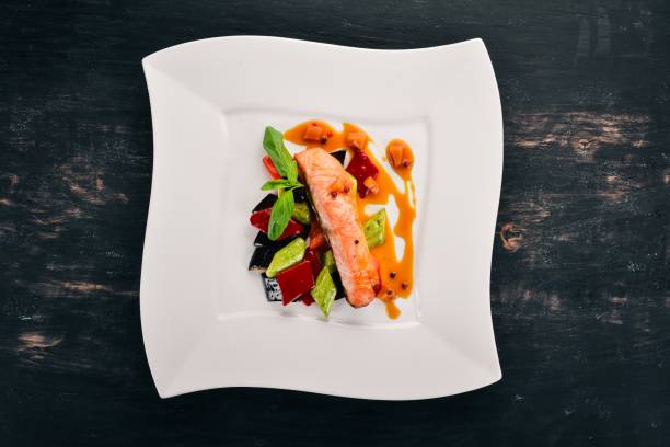 istock Baked Salmon Steak with Vegetables. On a wooden background. Top view. Copy space. 932137064