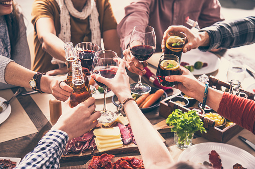 Group of people having meal togetherness dining toasting glasses
