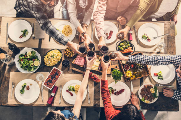 istock Group of people having meal togetherness dining toasting glasses 932137730