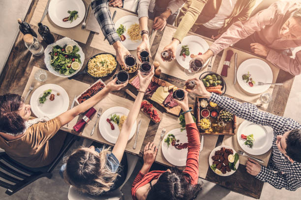 istock Group of people having meal togetherness dining toasting glasses 932139520