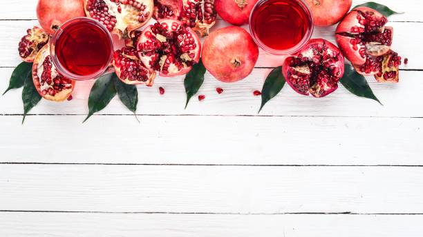 istock Fresh pomegranate juice. Pomegranate. On a white wooden background. Top view. Copy space. 932140184