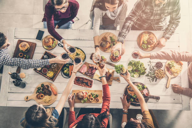 Group of people having meal togetherness dining toasting glasses