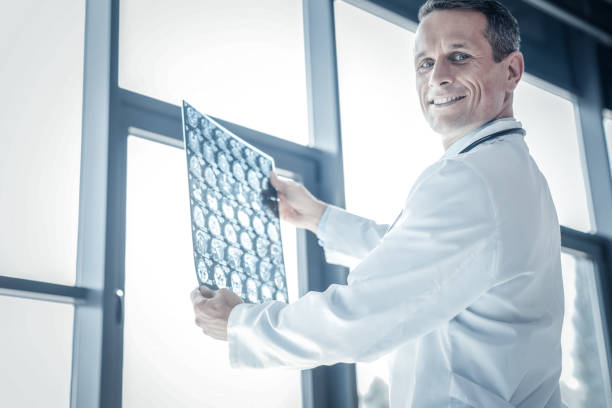 istock Confident skilled medic smiling and holding x-ray scan. 932142150