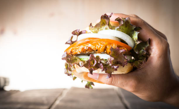 istock man holds burger with hands and potato chip. 932148512