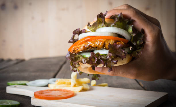 istock man holds burger with hands and potato chip. 932148554
