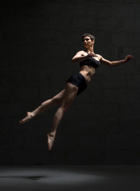 istock Ballet dancer in top and shorts view in dark room 932148656